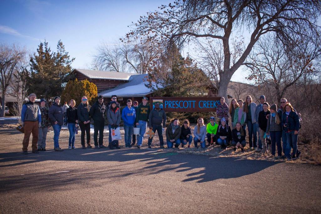 A group of individuals posed for a picture on a road, capturing the essence of nature in the background.