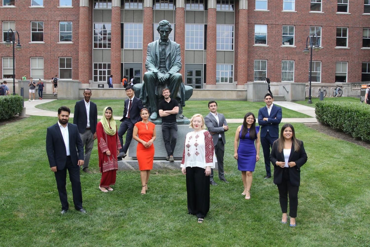 A gathering of Humphrey Fellows standing in front of a statue.