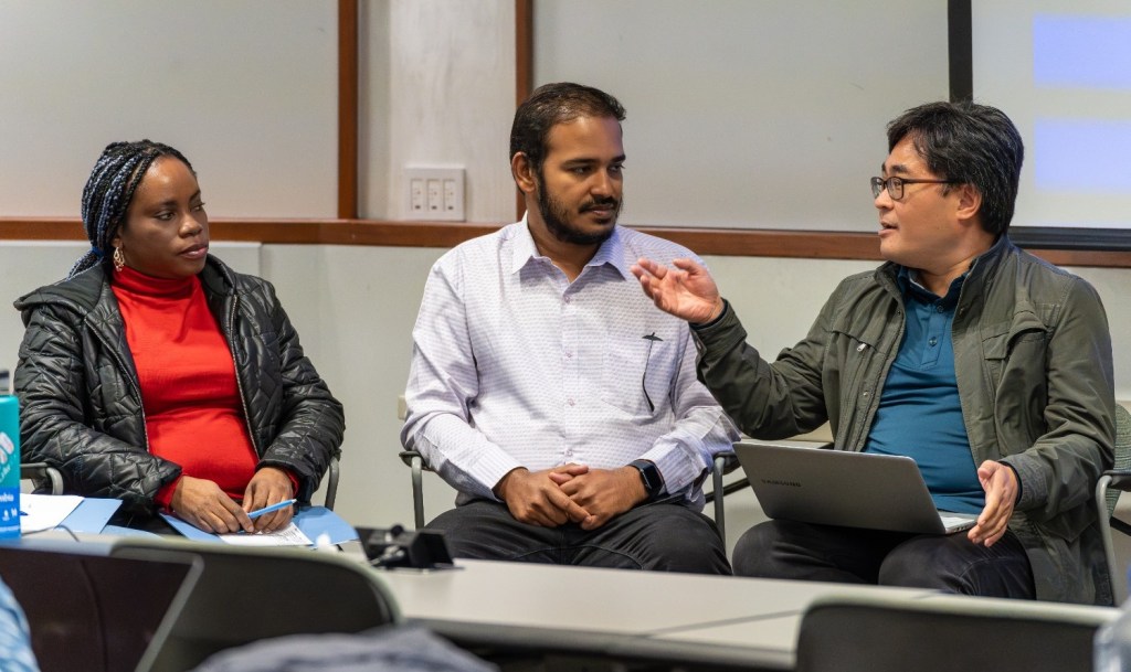 Three people seated, engaged in a serious discussion.