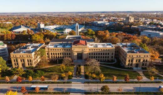 an aerial view of a large building surrounded by trees.