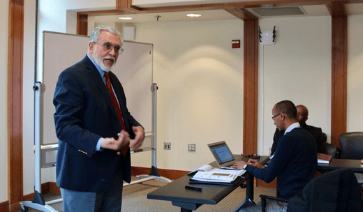 A professor at Duke University, actively involving the audience during a classroom session.