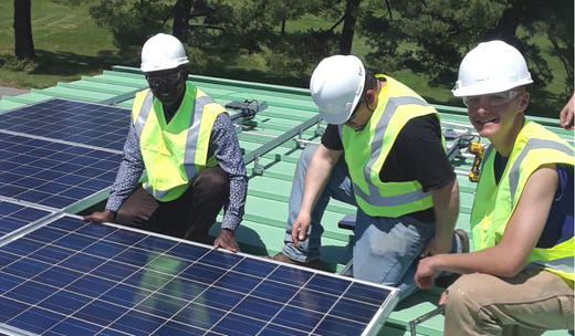 Men installing solar panel under the guidance of Emmanuel Ajani during the training session.