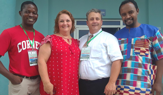 A woman and three men gathered for a picture.