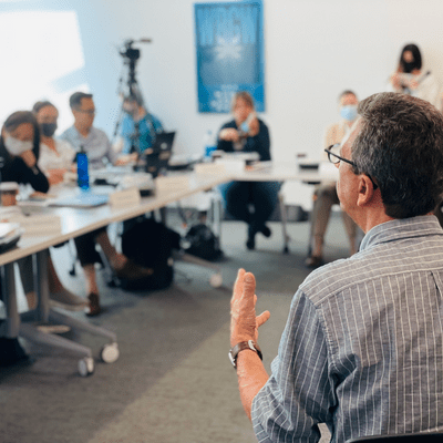 A man addressing people in a conference room.