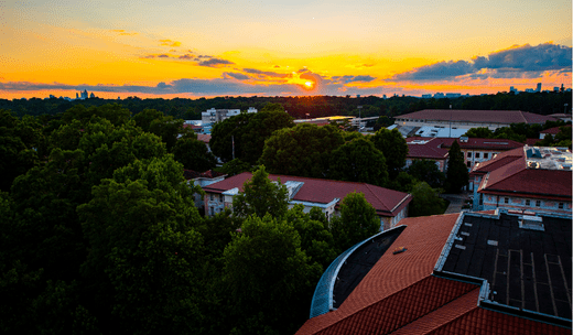 a sunset view of a city with a clock tower.