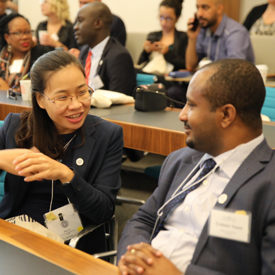 A woman and a man engaged in intense discussion in a conference hall.