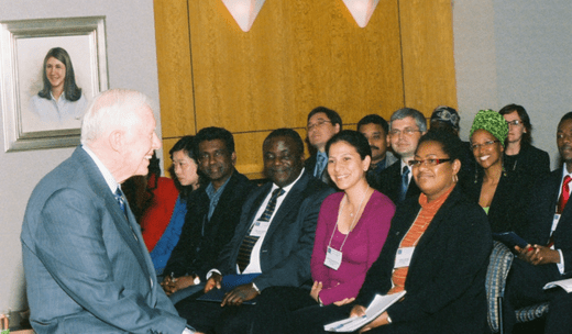 A man lecturing a group of people sitting in a room.