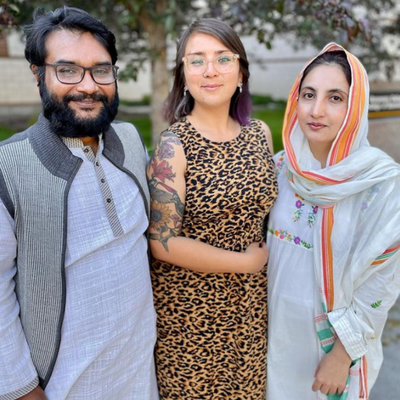 A man and two women happily posing for a photograph.
